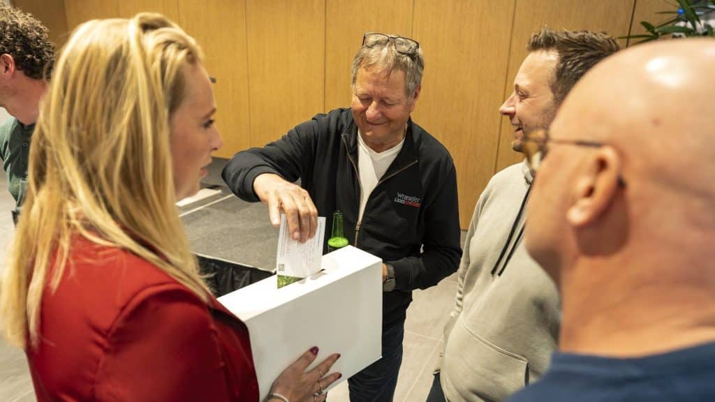 Bezoeker werpt kaart met idee in de brievenbus.