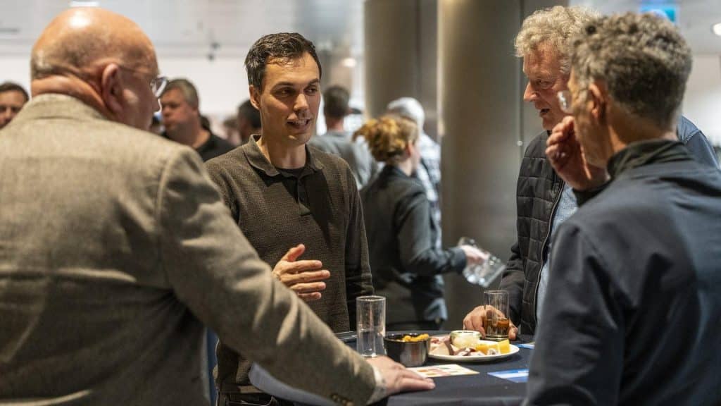 Een gesprek tussen bezoekers tijdens de netwerkborrel.