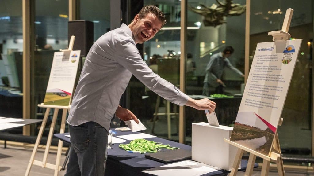 Bezoeker werpt kaart met idee in de brievenbus.