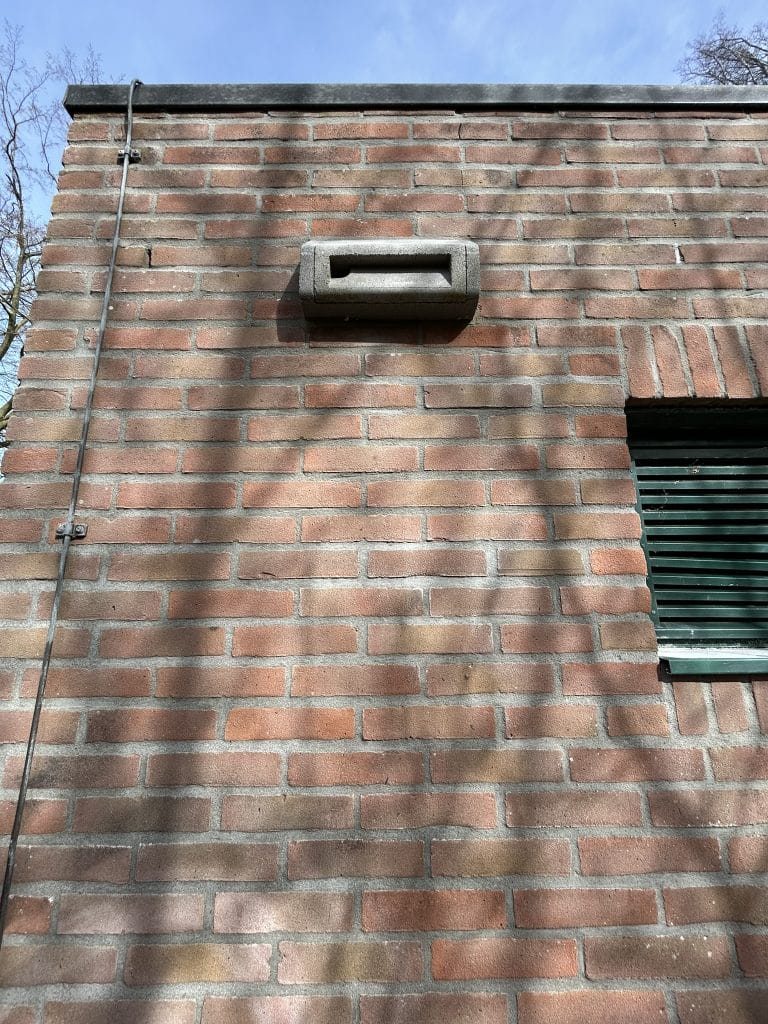 In de wand van het rioolgemaal is een vogelnestkast geplaatst. Dit is een grijze rechthoekige betonnen gleuf die in de muur gemetseld is. 